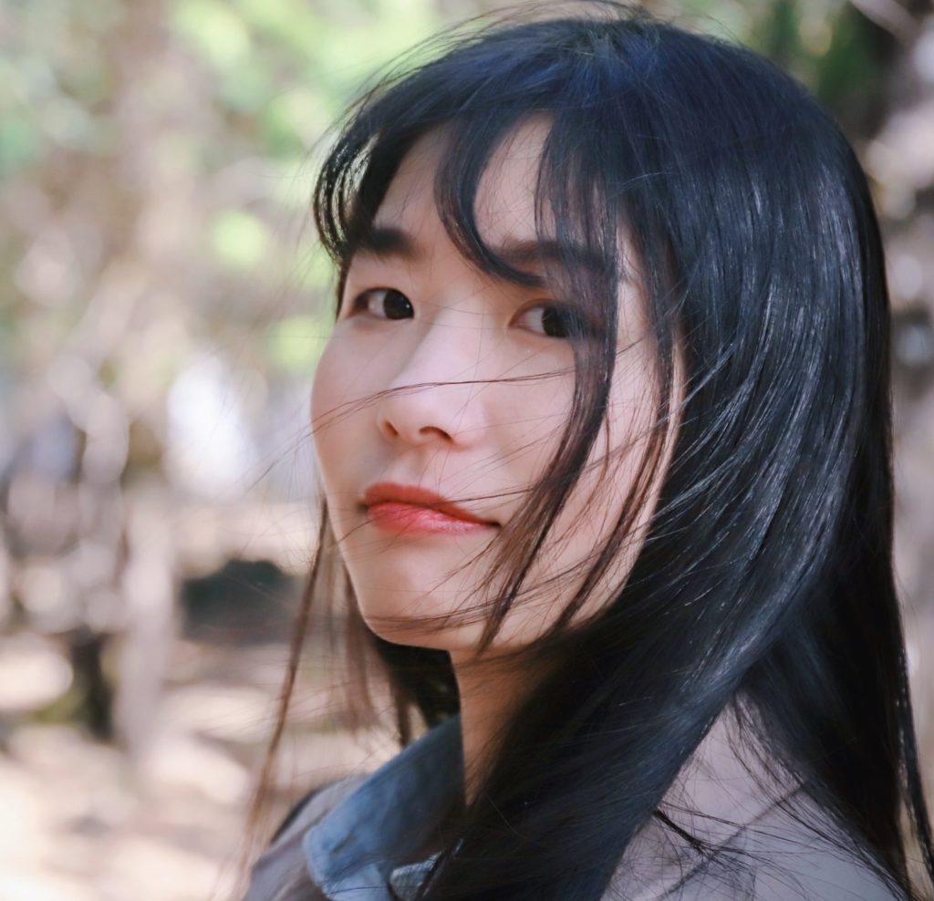 A woman with dark hair looks at the camera.